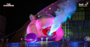 Large inflatable mascot with smoke effects and lighting at a nighttime event