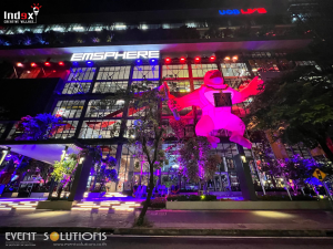 Large inflatable mascot displayed at a shopping mall during nighttime