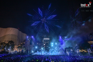 Drone light show event production creating visual performance above large outdoor audience