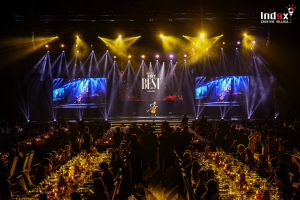 Professional event production for gala dinner featuring stage lighting design, LED screens, and live performance