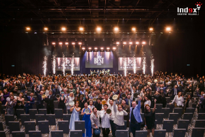 Large corporate awards ceremony with stage production, lighting effects, and audience celebration